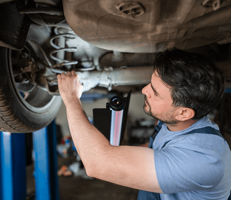 Auto technician working underneath vehicle